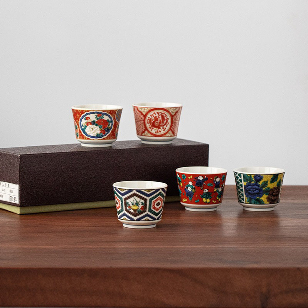 Angled top-down view of Kutaniyaki tea cups showing intricate patterns and glaze