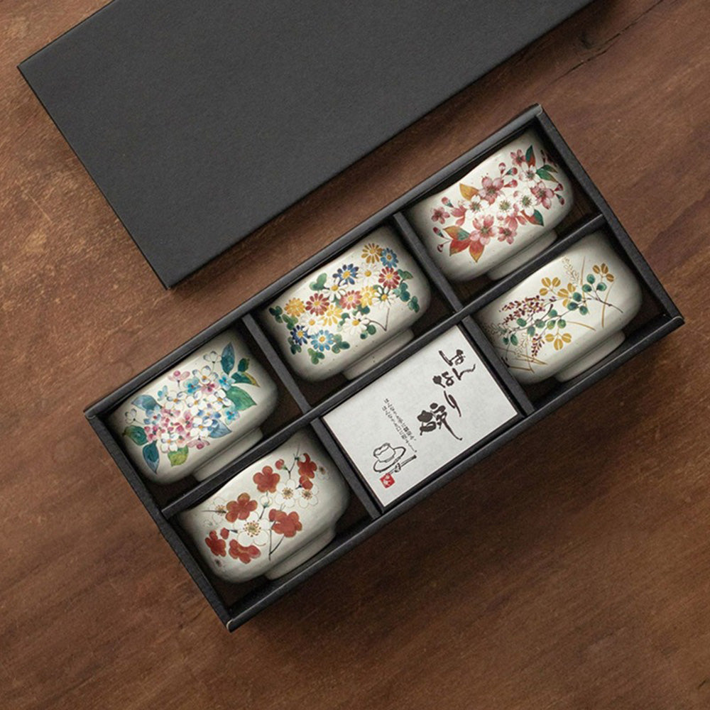 Mino-yaki tea cup set with seasonal flower designs, elegantly displayed in a wooden box.