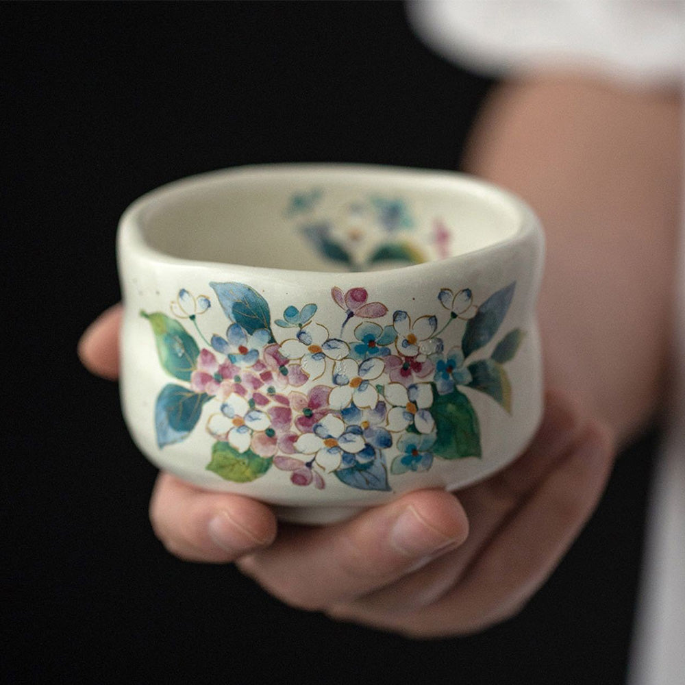 Mino-yaki tea cup set with seasonal flower designs, elegantly displayed in a wooden box.