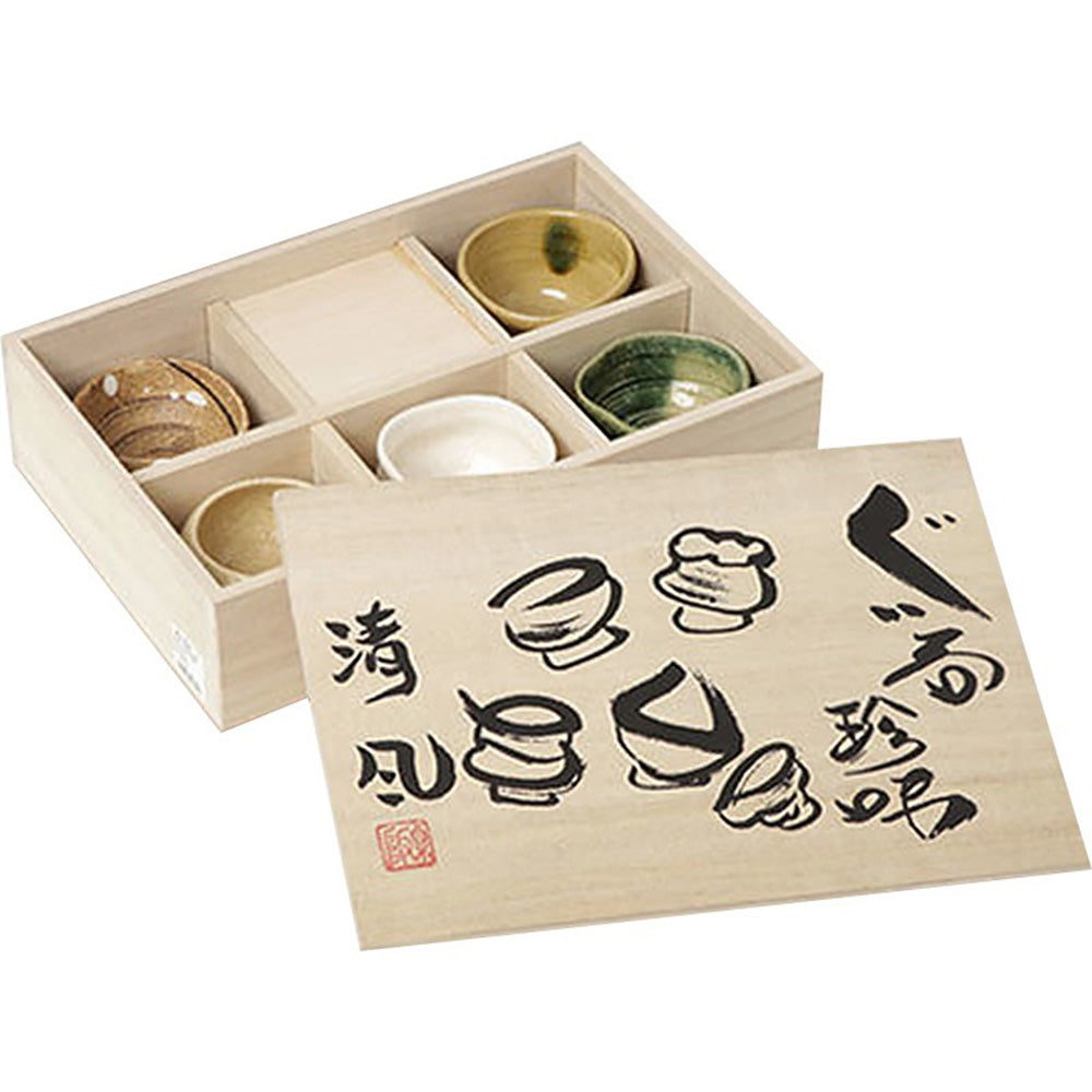 A hand holding a Mino-yaki tea cup, emphasizing the comfortable grip and elegant design.