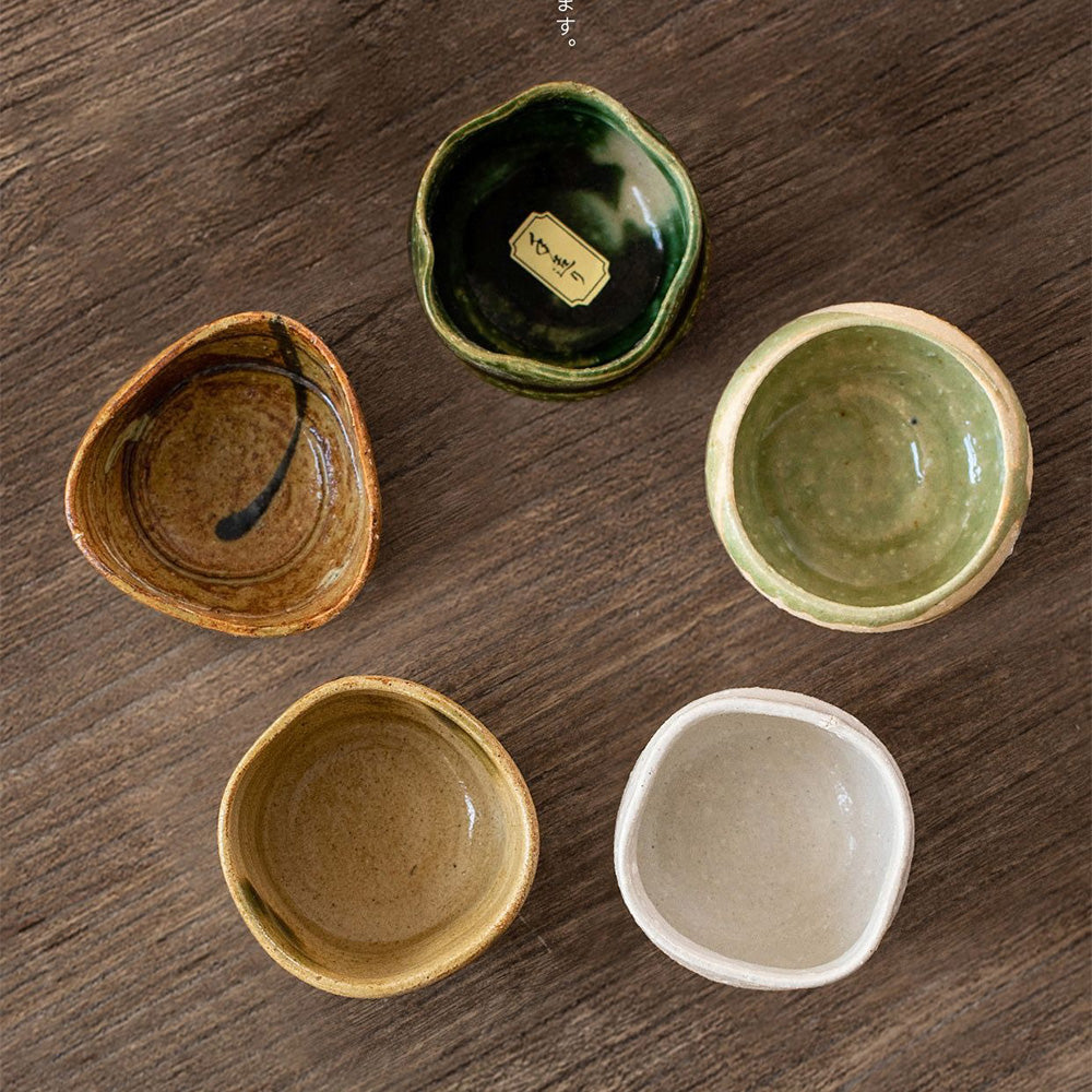 Close-up of the earthy-toned Mino ware pottery tea cups, highlighting their textured glaze.