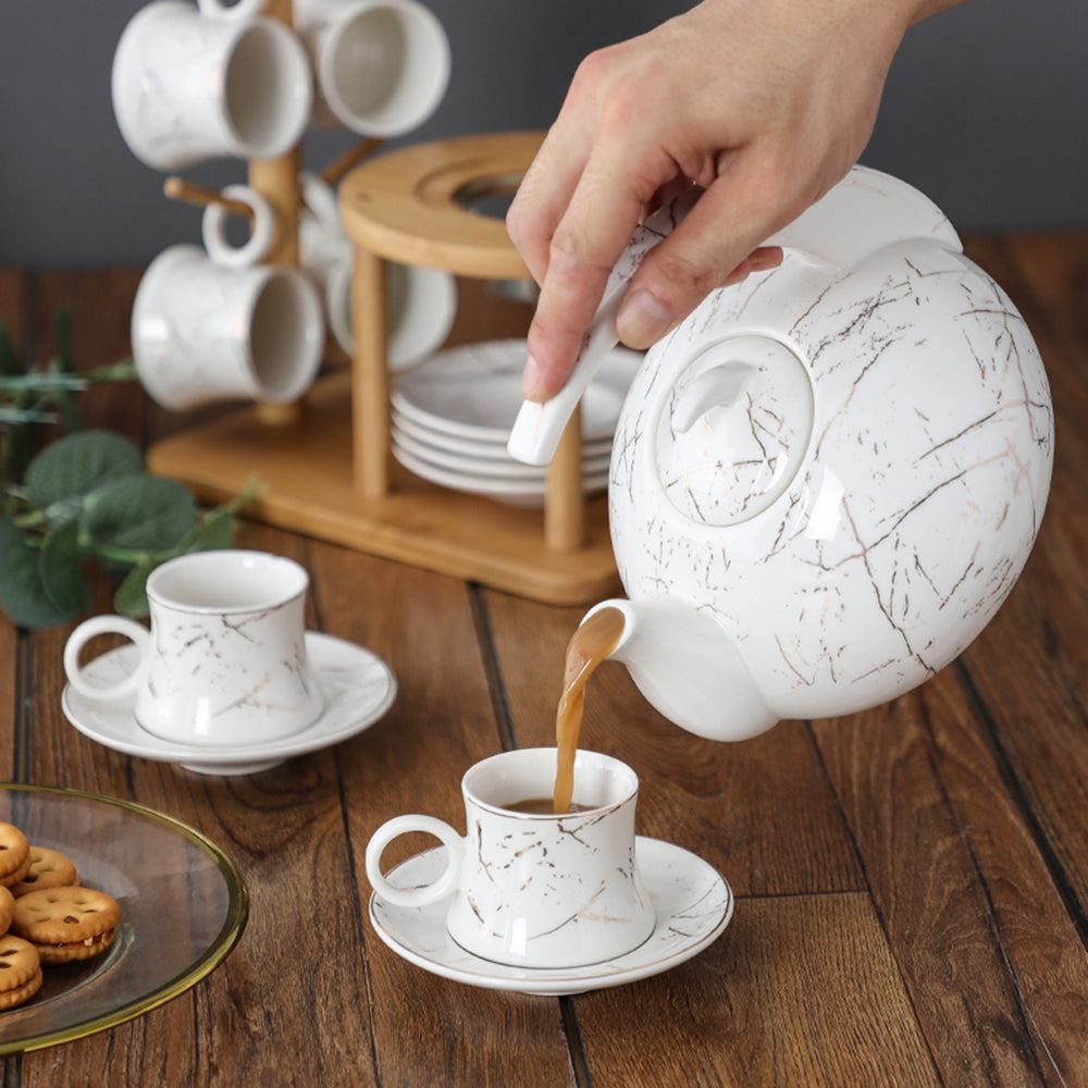 Close-up of marble texture ceramic teapot with bamboo rack for elegant tea serving