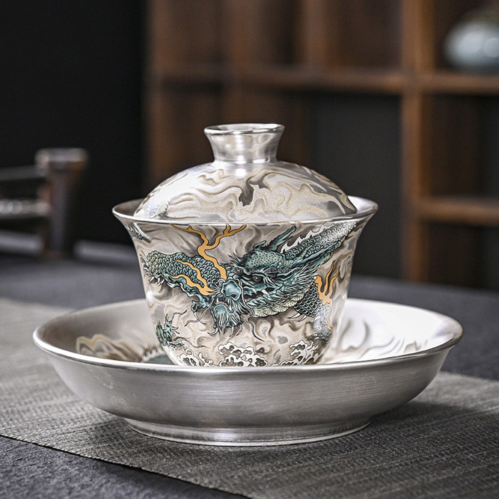 Close-up of hand-painted blue dragon on sterling silver tea set
