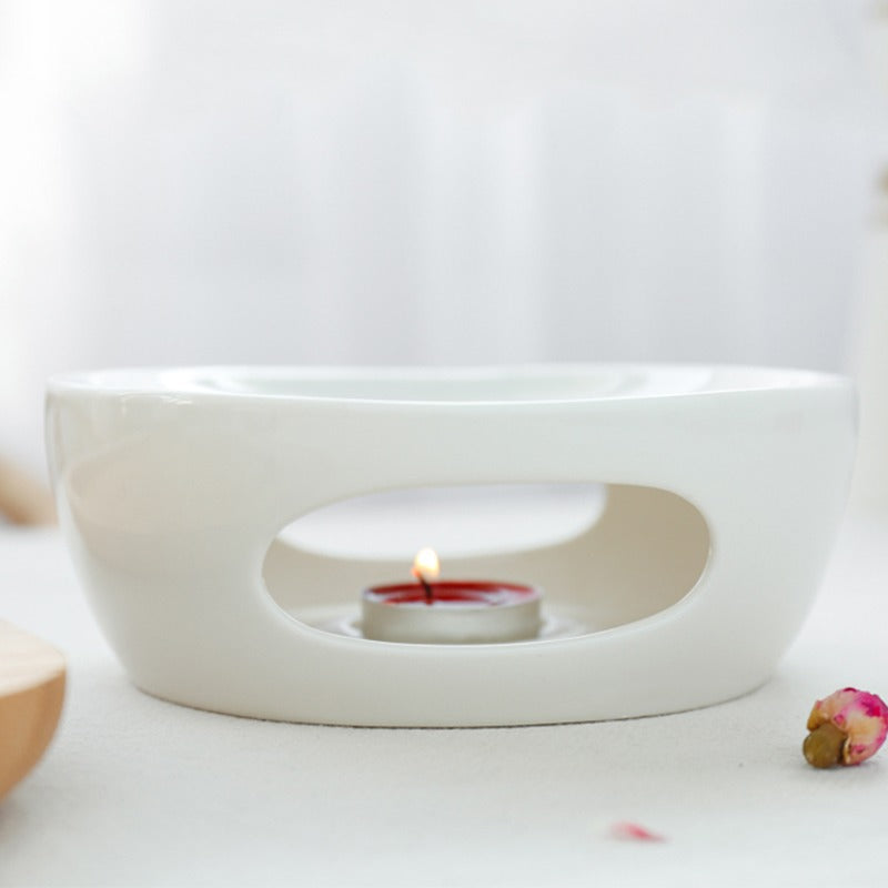 Side view of porcelain teapot warmer in use with steaming tea.