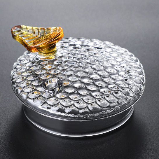 Side view of borosilicate glass teapot with leaf-shaped lid and infuser
