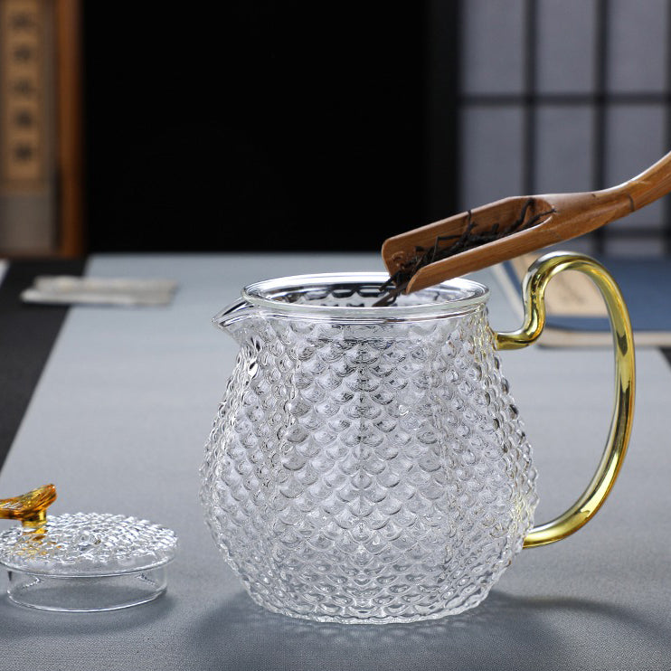Tea brewing in transparent glass teapot with blooming flower tea