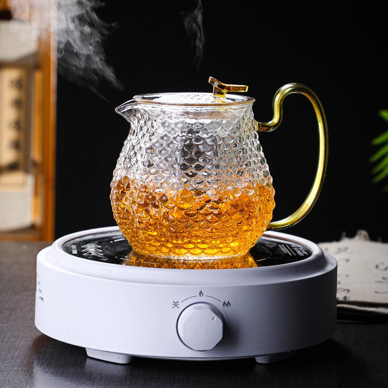 Side view of borosilicate glass teapot with leaf-shaped lid and infuser