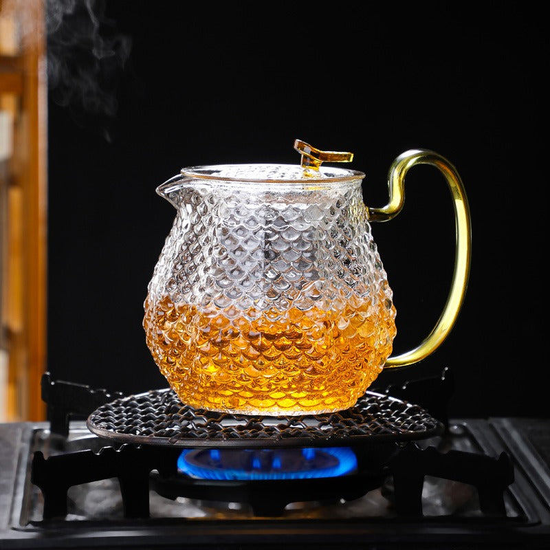 Tea brewing in transparent glass teapot with blooming flower tea