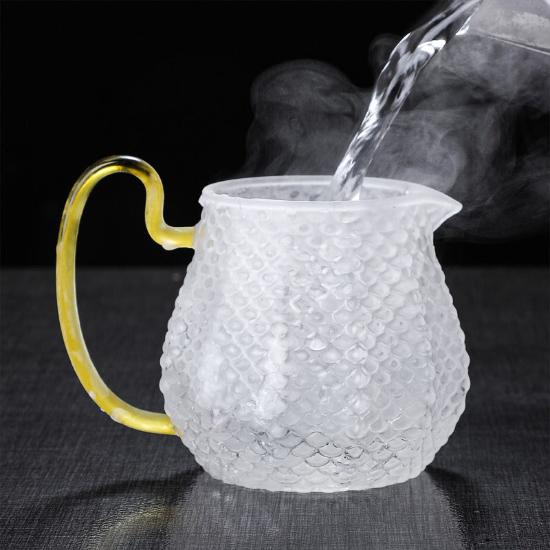 Close-up of colorful handle glass teapot with infuser for flowering tea