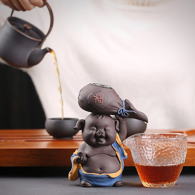 Top view of purple clay pig tea strainer filtering loose leaf tea into fair cup
