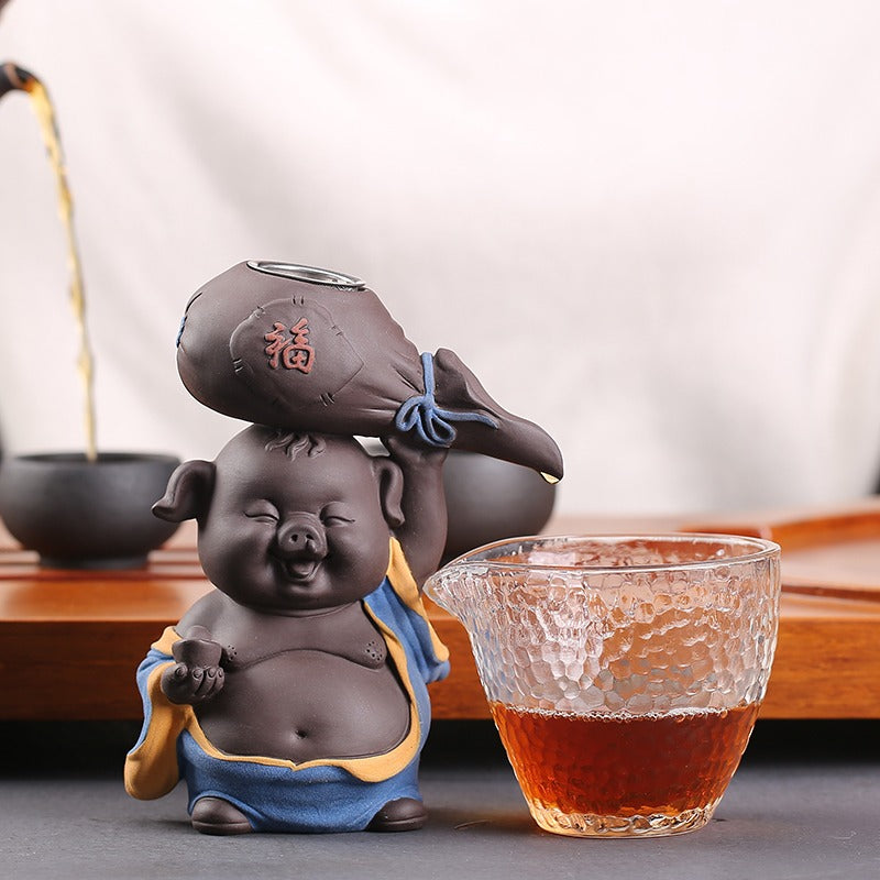 Top view of purple clay pig tea strainer filtering loose leaf tea into fair cup