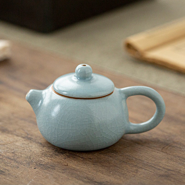 Angled view showing Ice Crack glaze of the ceramic teapot resting on wooden tray