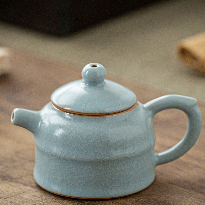 Mini teapot placed beside tea pet figurines, highlighting its collectible charm
