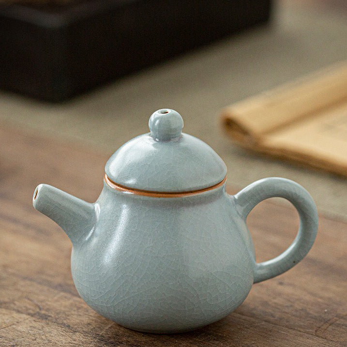 Angled view showing Ice Crack glaze of the ceramic teapot resting on wooden tray