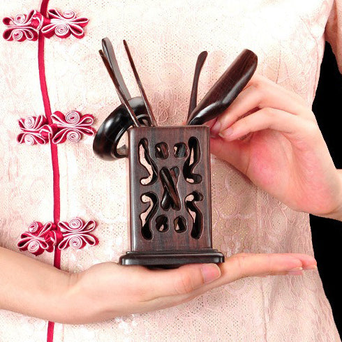 Close-up of the tea scoop and funnel from the Black Hollow tea utensil set, highlighting their craftsmanship.