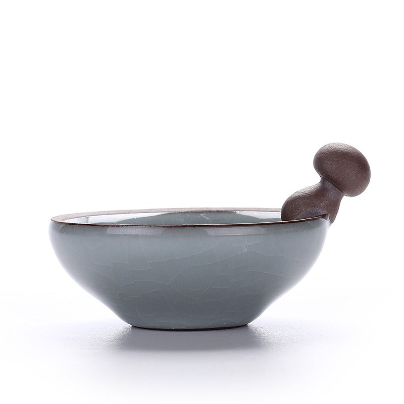 Front view of Ge Kiln tea infuser and holder set on a tea table