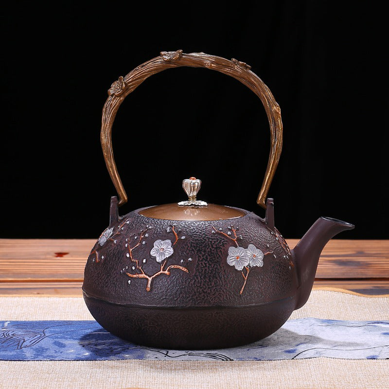 Elegant Japanese plum cast iron teapot showcasing the copper ring handle and flower bud lid.