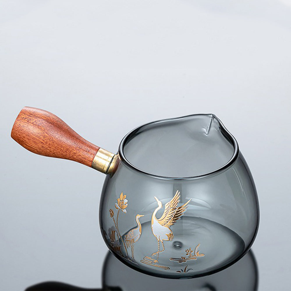 Close-up of the teapot from the premium glass tea set, highlighting the intricate crane pattern and rosewood handle.