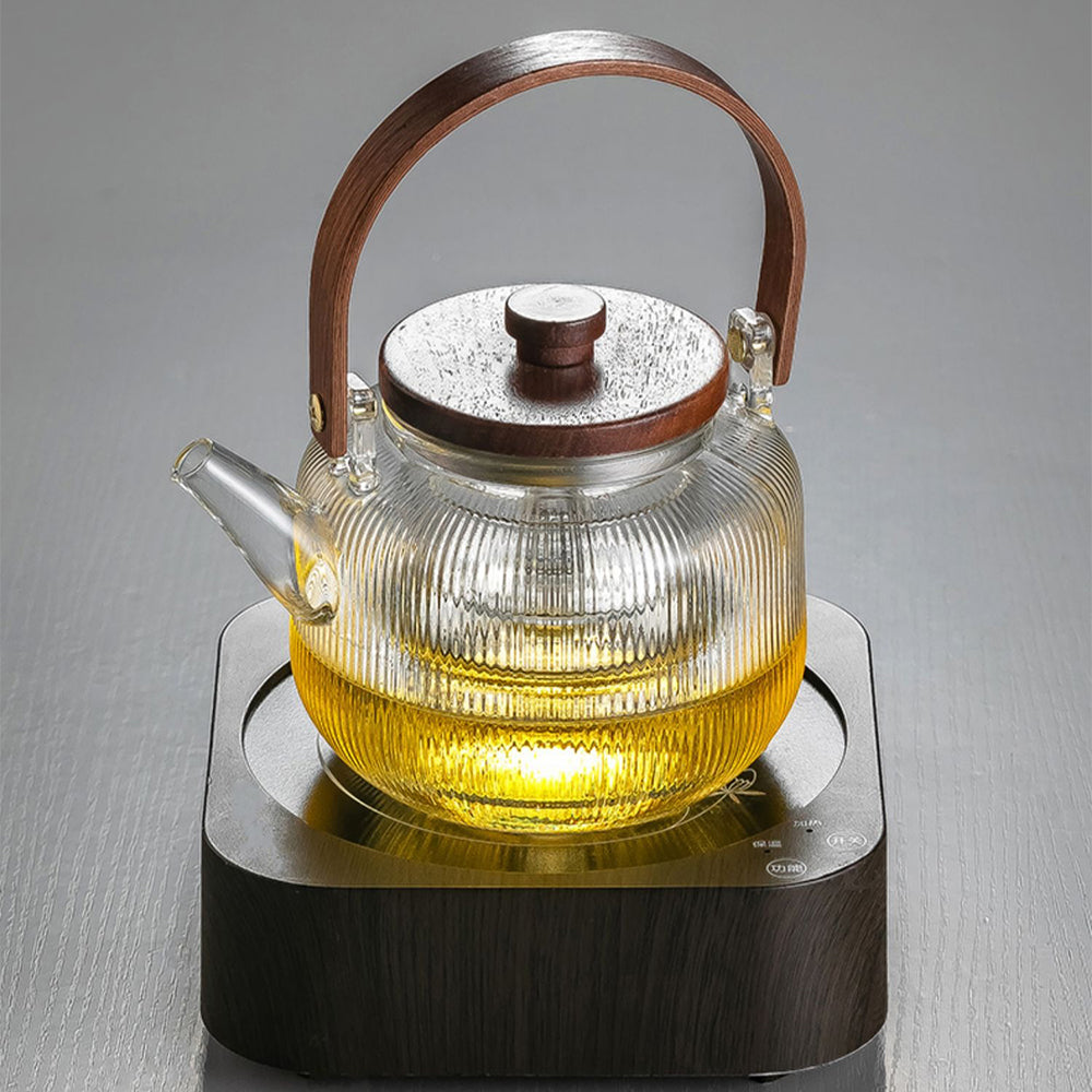 Set of six tea cups alongside the glass teapot on a wooden tray