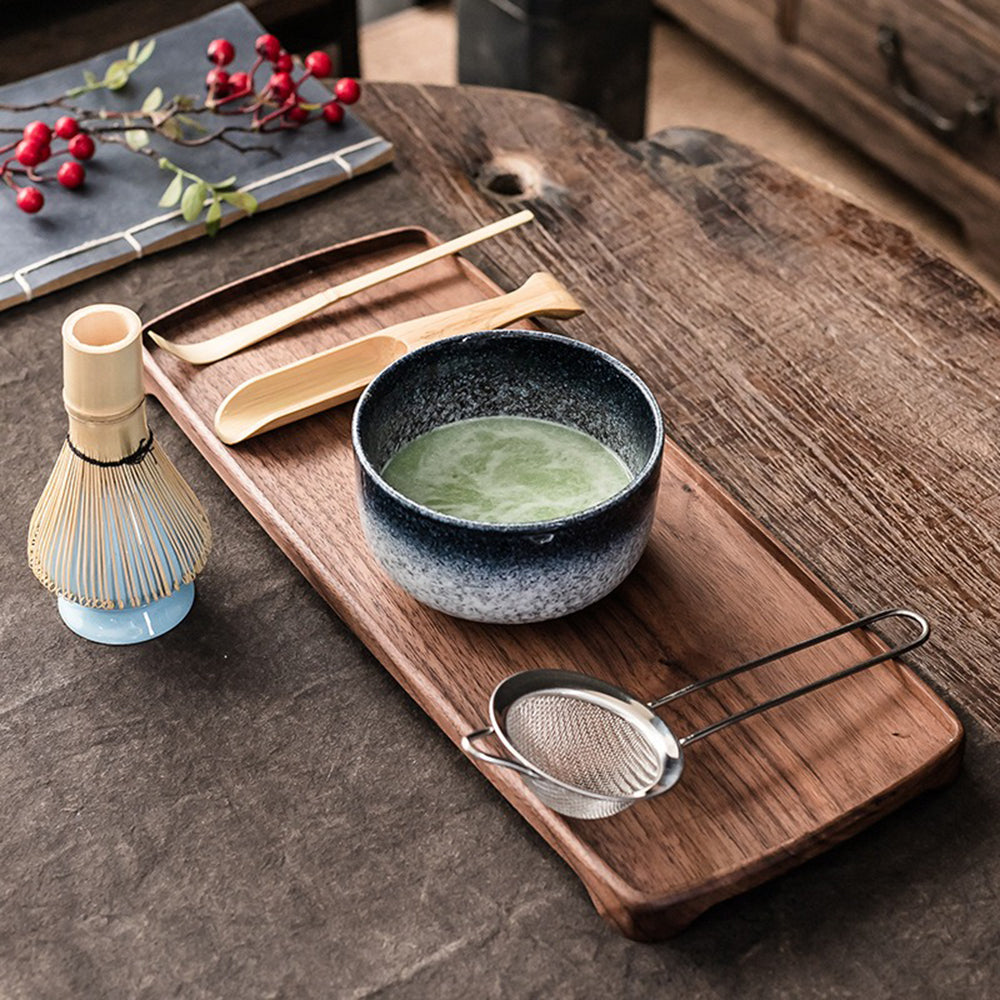 Organic matcha whisk set displayed alongside the ceramic whisk holder and other accessories.