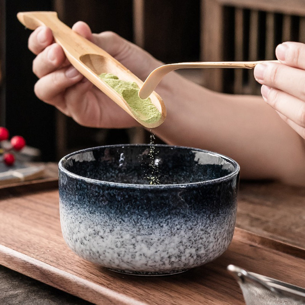 Organic matcha whisk set displayed alongside the ceramic whisk holder and other accessories.