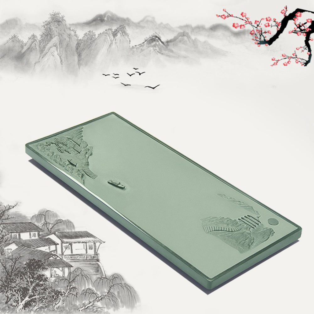 Close-up of the detailed carvings on the green stone gongfu tea tray showcasing natural landscape scene