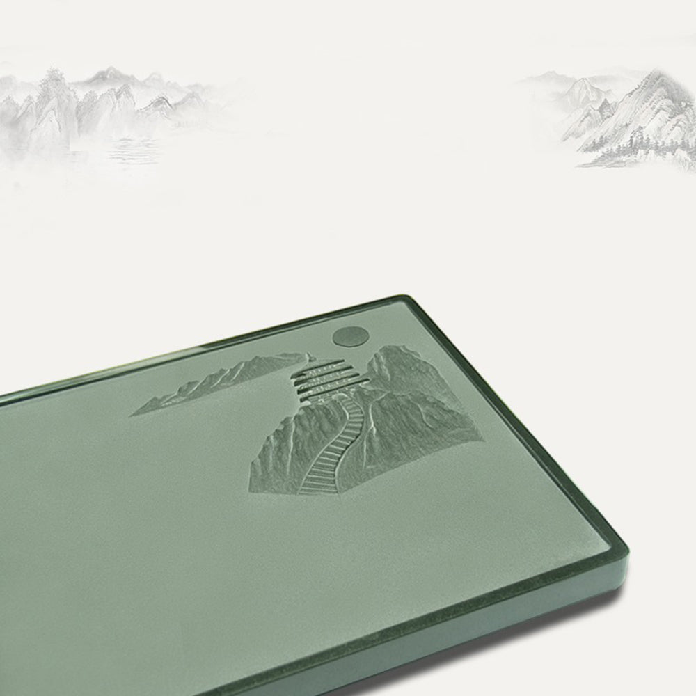 Close-up of the detailed carvings on the green stone gongfu tea tray showcasing natural landscape scene