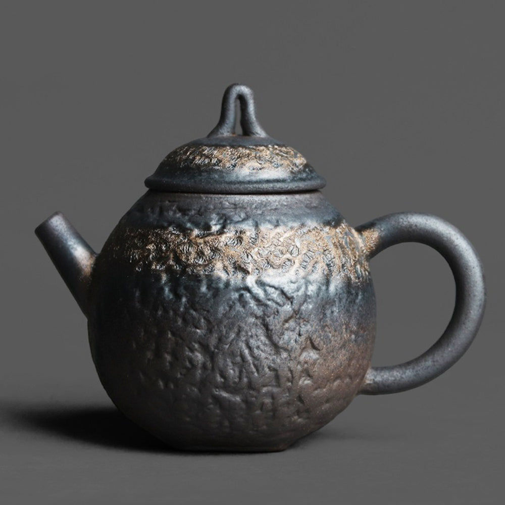 Side view of the purple clay Yixing teapot showing its hammered stone texture and gilded glaze