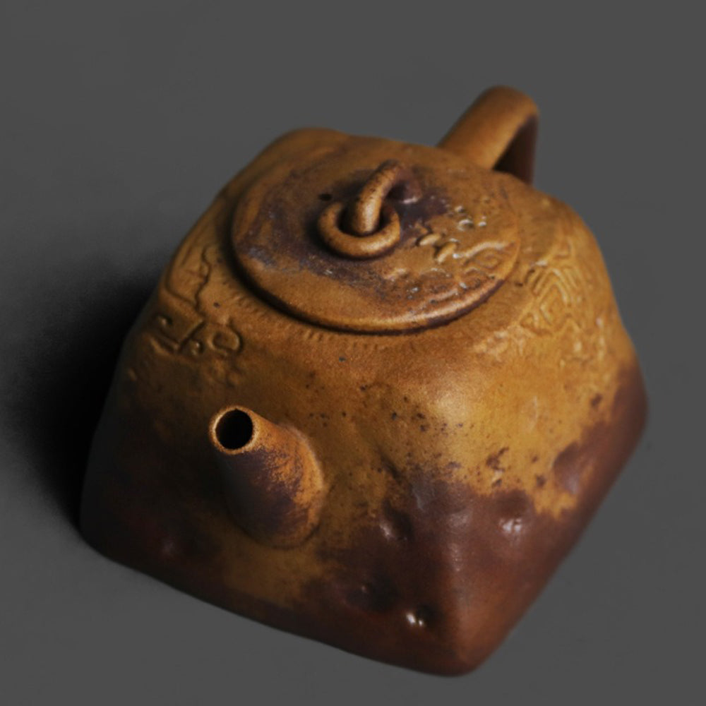 Handheld ceramic teapot with square base and cultural relief details, ideal for tea brewing