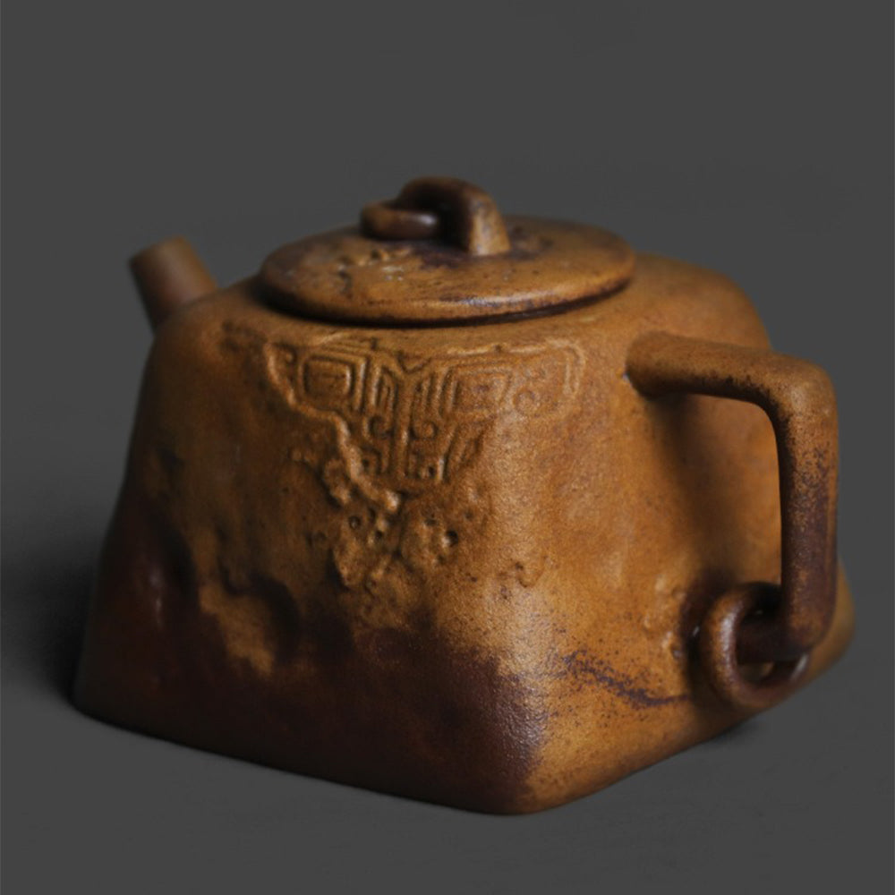 Side view of the artistic ceramic teapot highlighting its square lid knob and cultural motifs