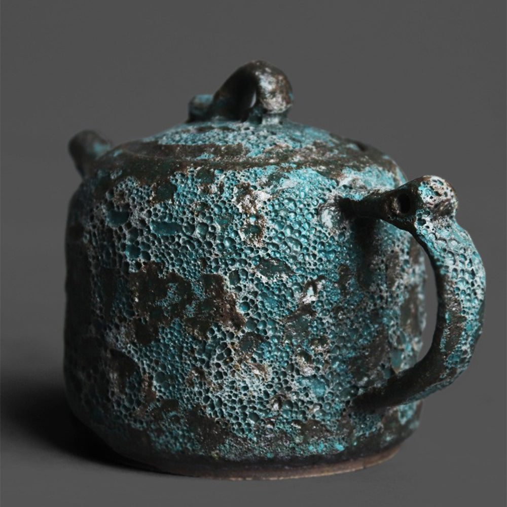 Side view of the handcrafted ceramic teapot highlighting its rich bronze glaze