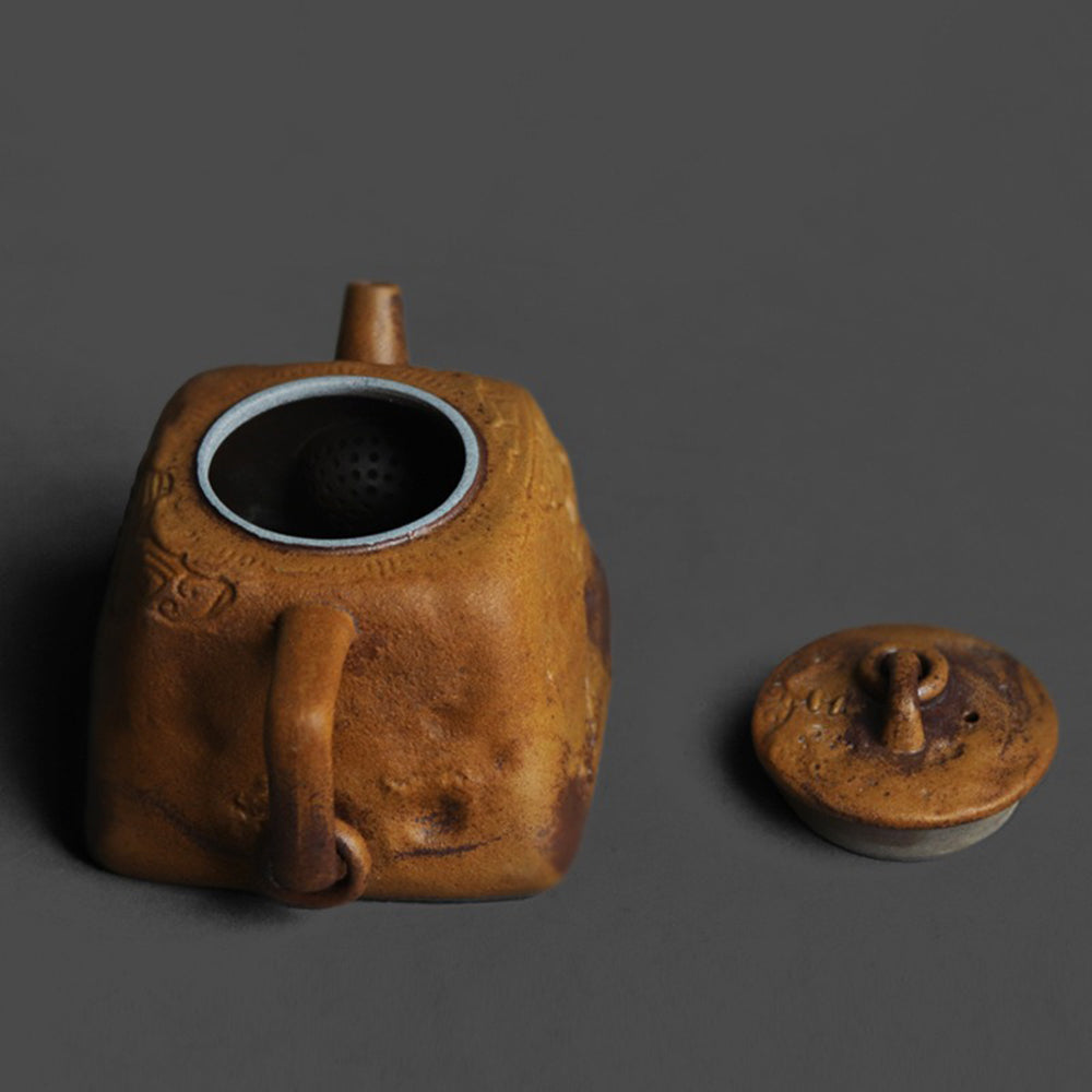 Close-up of the relief totem design on the ceramic teapot, showcasing traditional artistry