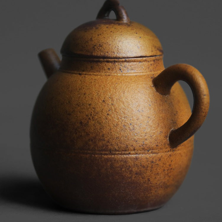Tea pouring from the traditional coarse pottery teapot during a tea session