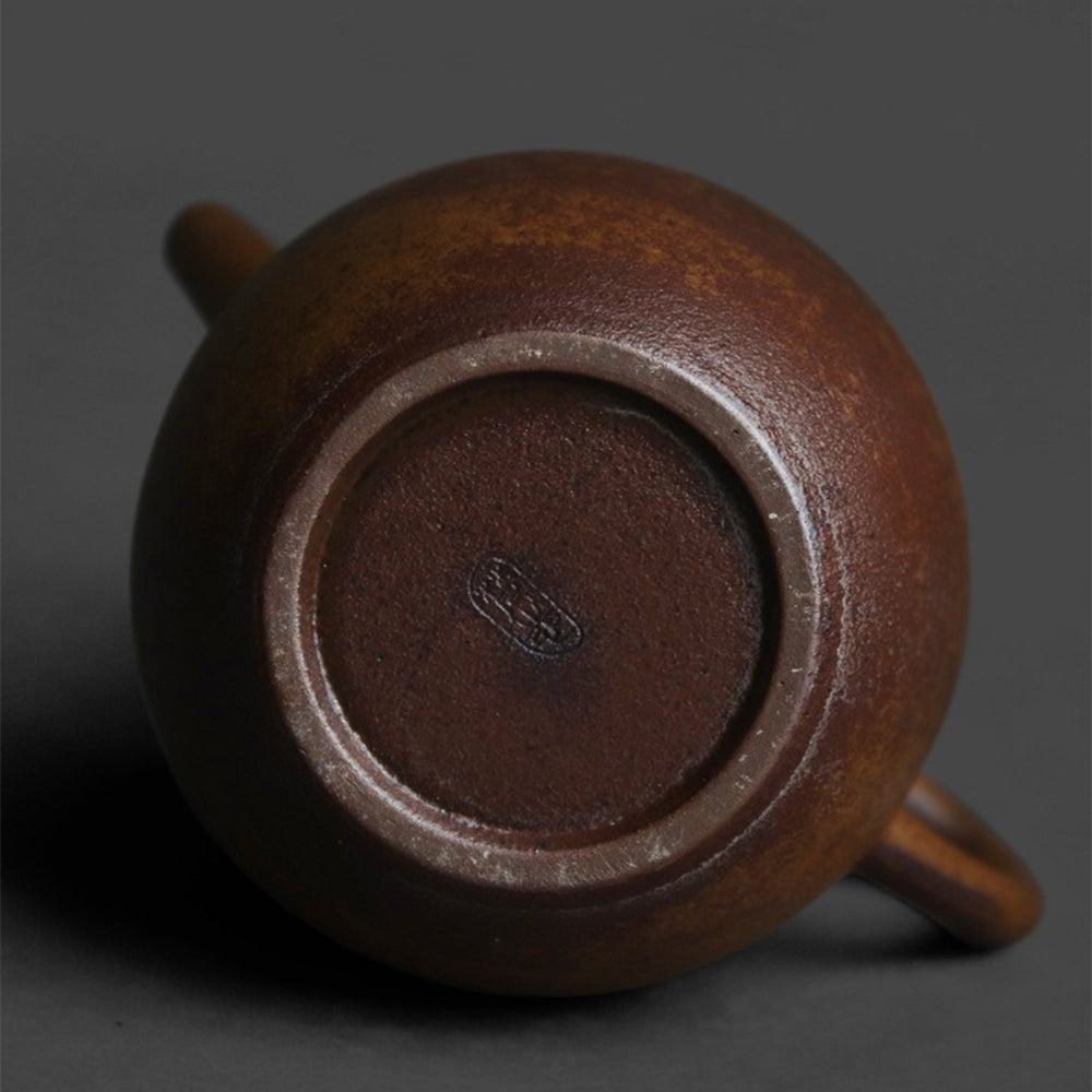 Tea pouring from the traditional coarse pottery teapot during a tea session
