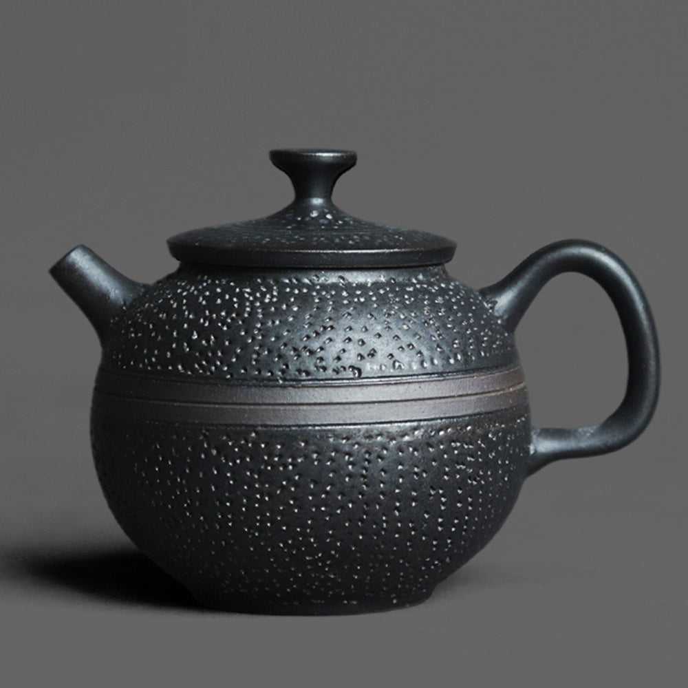 Close-up of black glaze round teapot showing handmade details and ergonomic handle