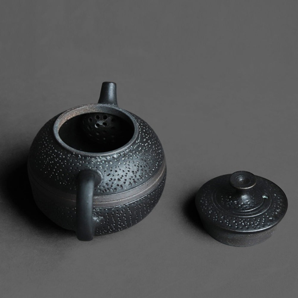 Close-up of black glaze round teapot showing handmade details and ergonomic handle