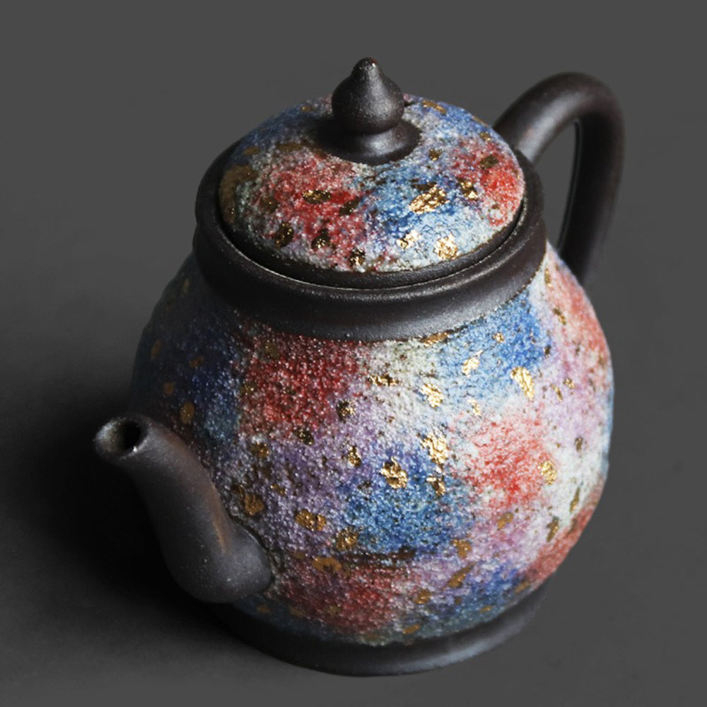 Side angle of the Chinese teapot highlighting its mineral texture and ergonomic handle