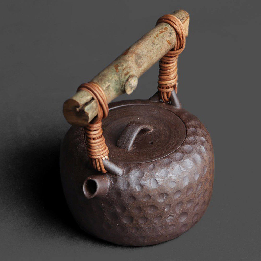Close-up of the wooden lid and rattan handle on a handmade Japanese teapot