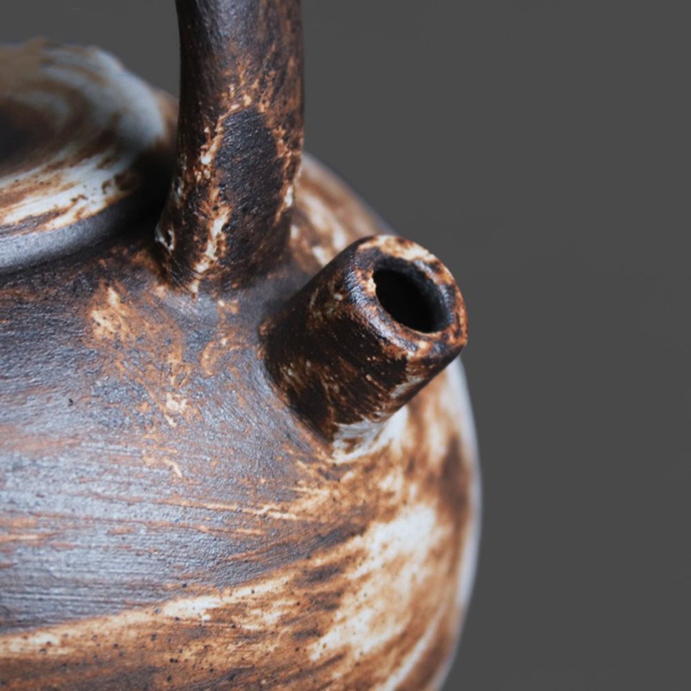 Elegant side view of the handcrafted ceramic teapot with twined hemp rope handle.