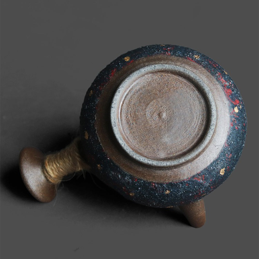Side view of the teapot highlighting the hemp rope handle and the elegant lid with a golden knob.