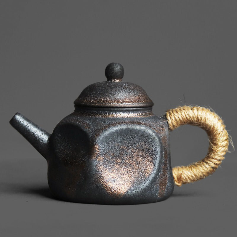 Close-up of the handcrafted Japanese ceramic teapot with dent design and black gold finish