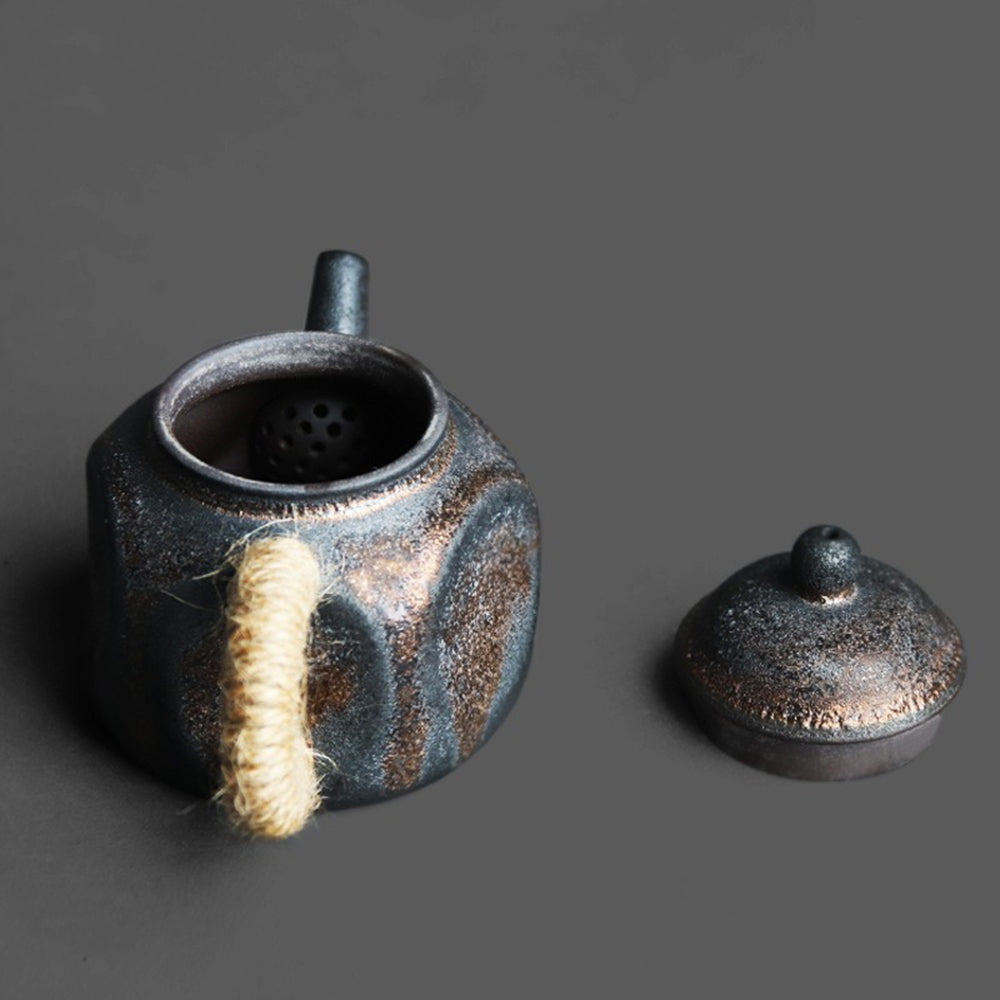 Close-up of the handcrafted Japanese ceramic teapot with dent design and black gold finish