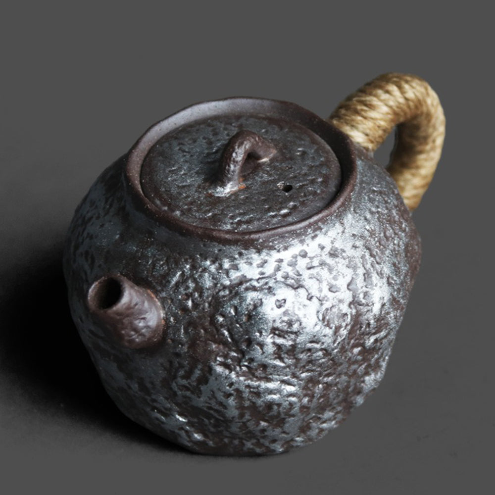 Side angle of the Gyokko Kiln teapot with hemp-wrapped handle and Tokoname ware finish