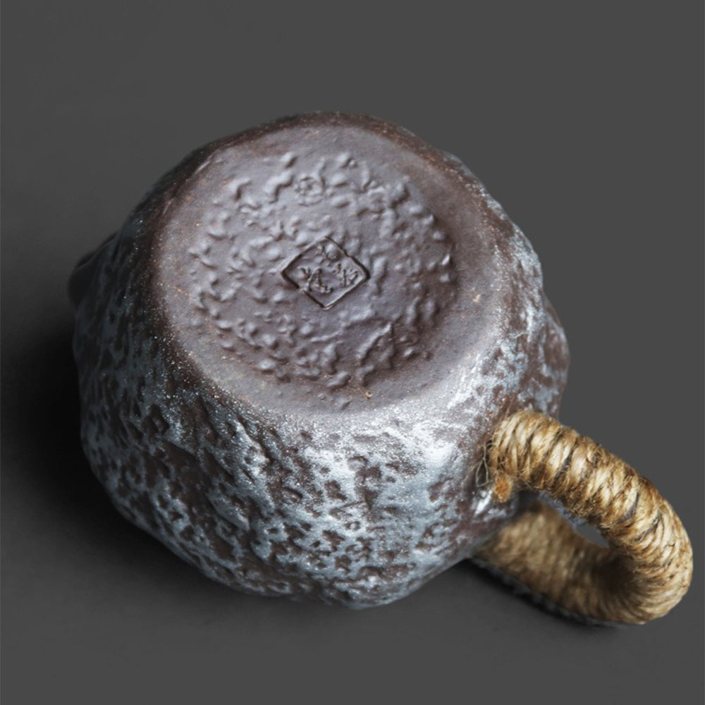 Side angle of the Gyokko Kiln teapot with hemp-wrapped handle and Tokoname ware finish
