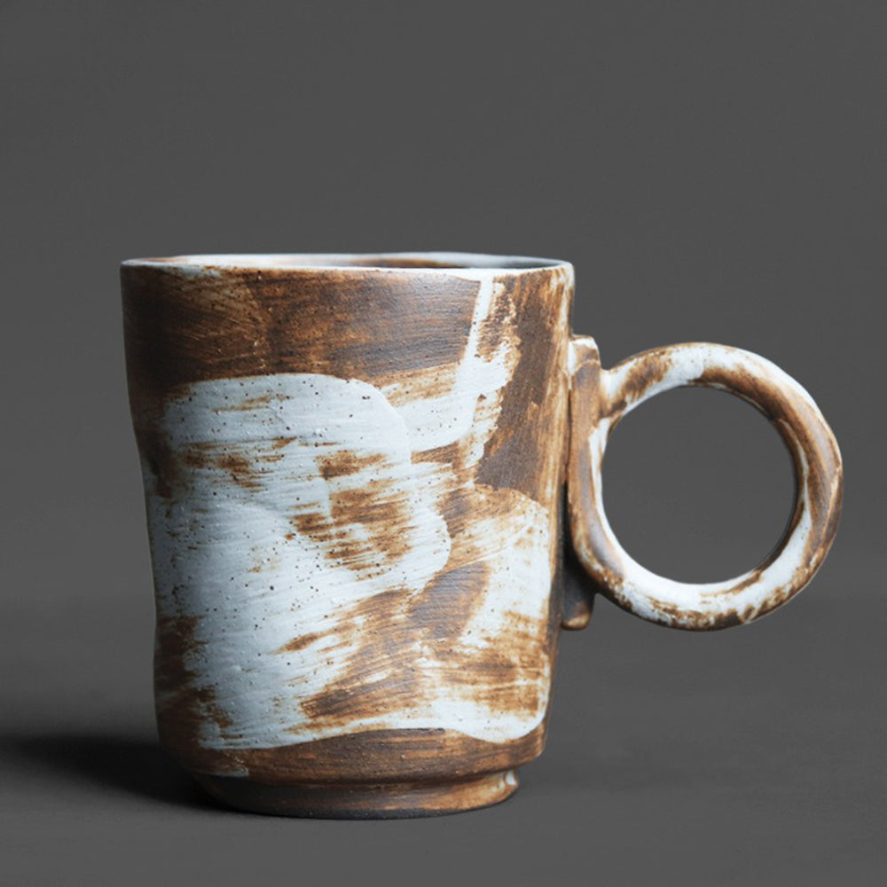 A close-up of a coarse textured ceramic mug with vintage glaze, perfect for tea or coffee.