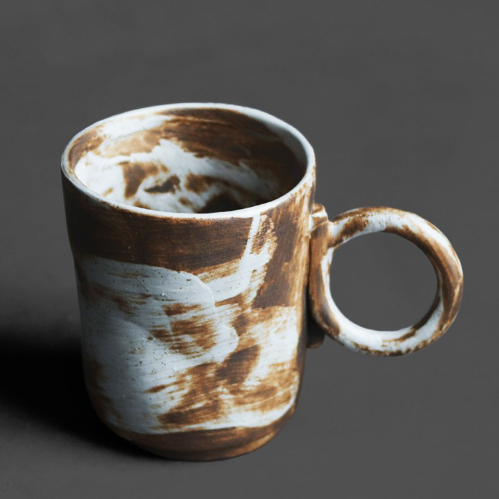 Handcrafted Japanese pottery mug with layered glaze pattern, ideal for daily use.