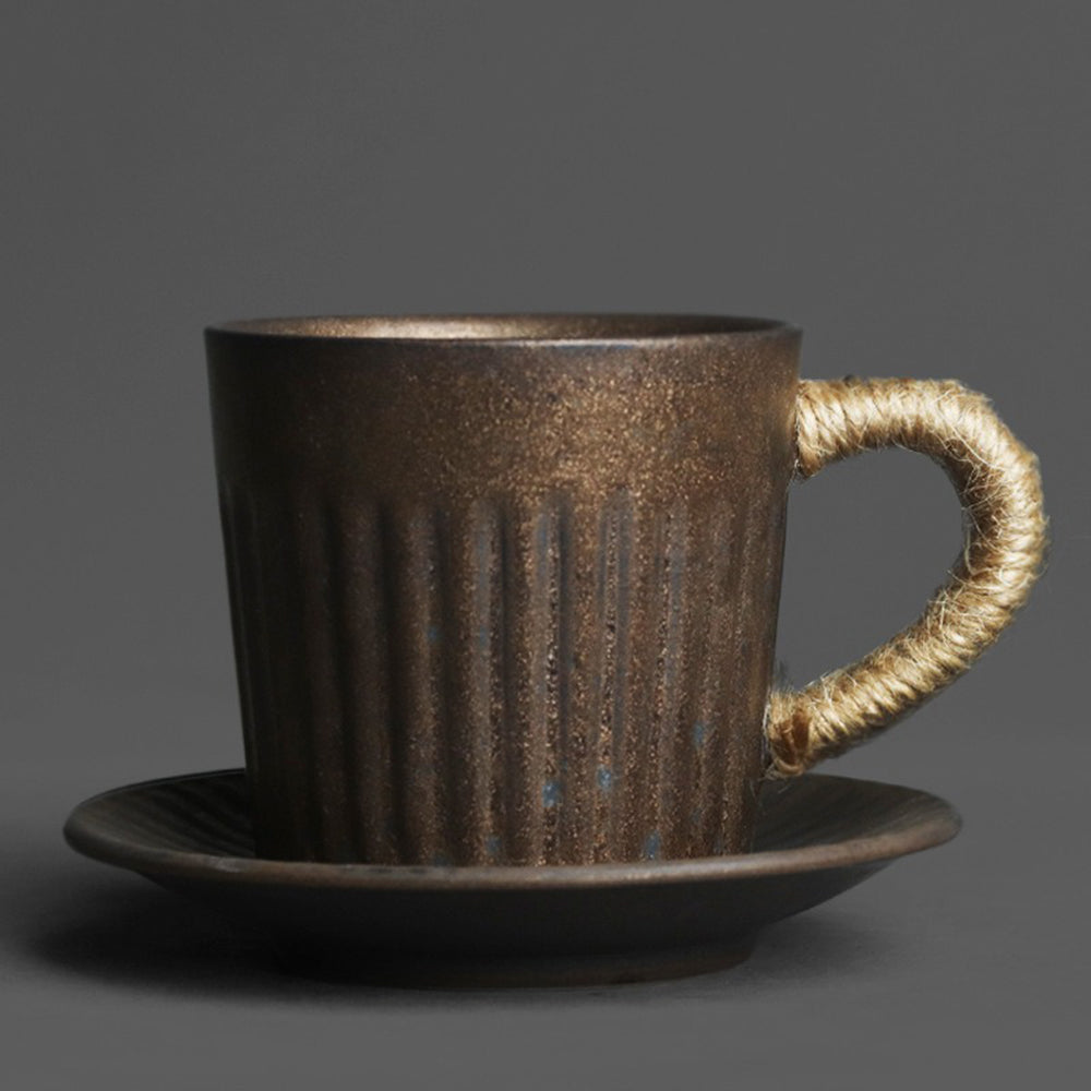 Close-up of black gold kiln coarse pottery tea cup with detailed texture and saucer