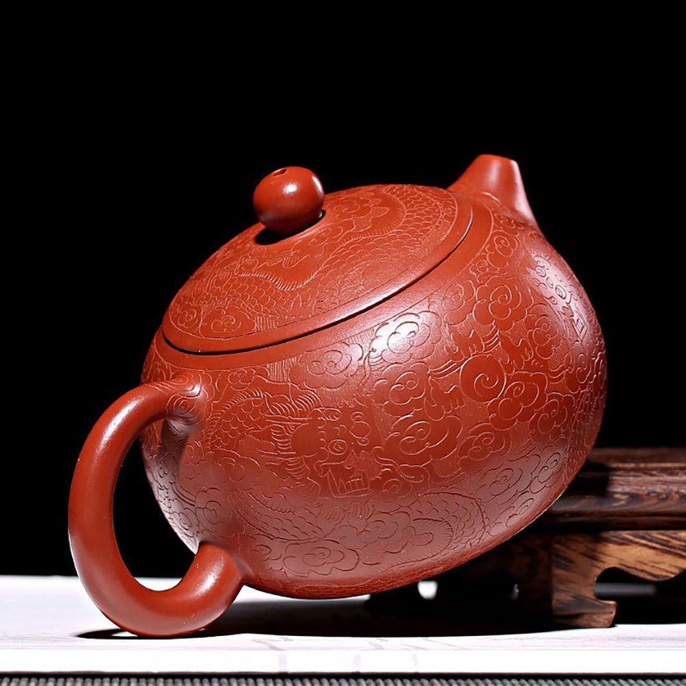 Elegant Yixing teapot with auspicious cloud patterns, perfect for tea ceremonies.