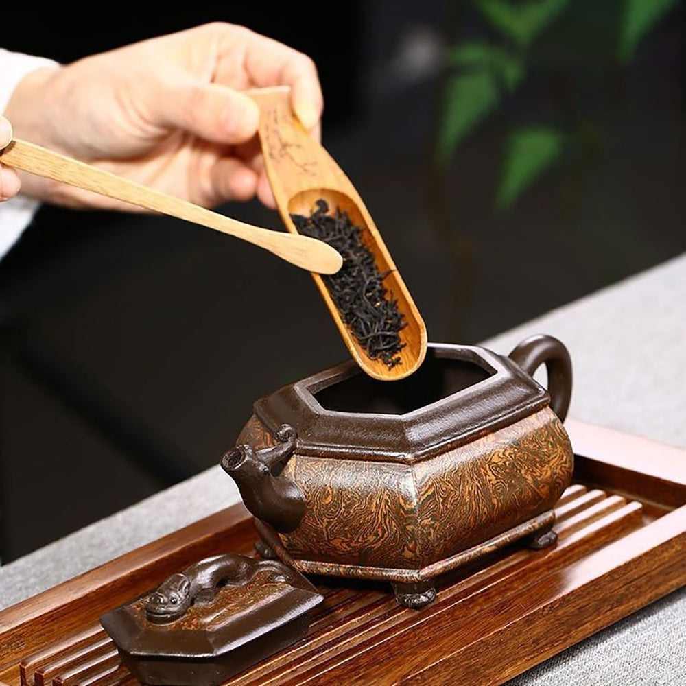 Side view of the Artisan Chilong Dragon Motif Teapot, emphasizing its unique spout and handle.