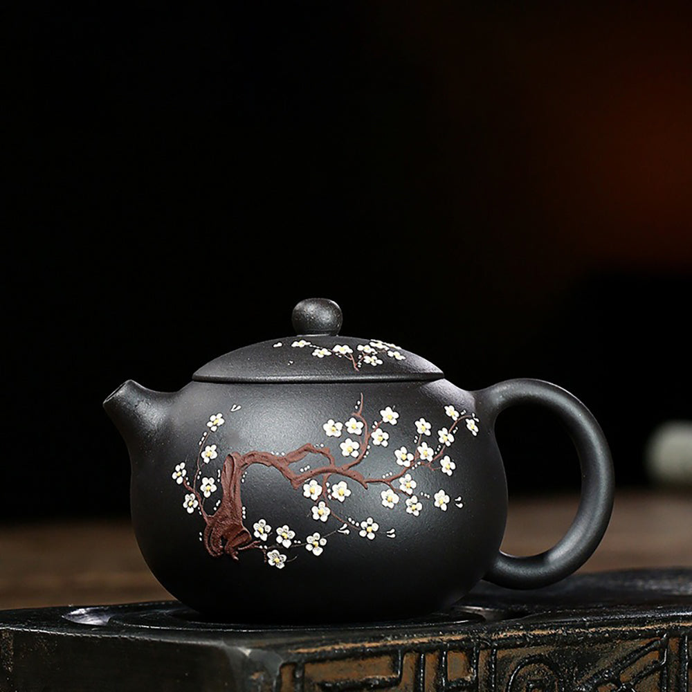 Close-up of the intricate plum blossom pattern on the body of the Yixing teapot, emphasizing its artistic details.